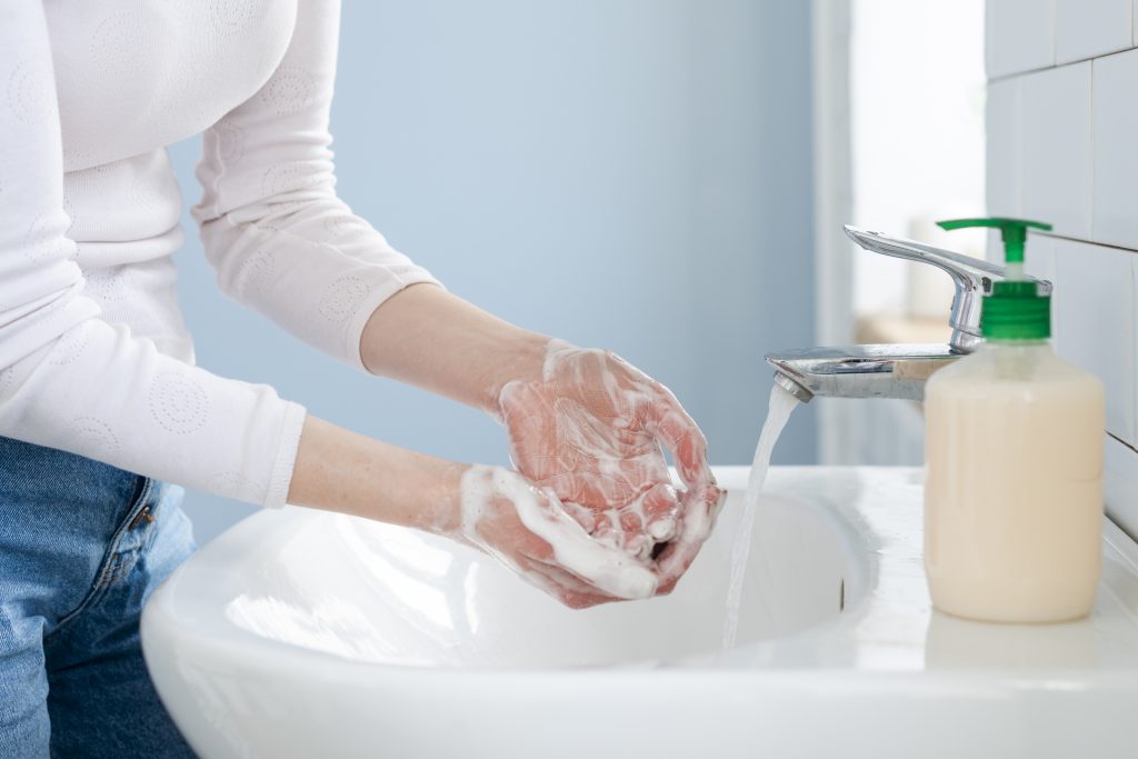 Pessoa higienizando as mãos